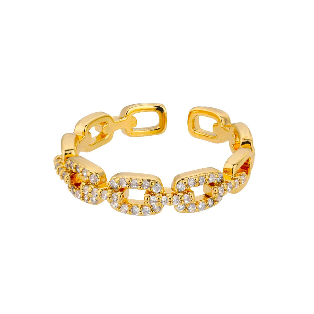 Classic Zircon Twist Chain Rings em ouro com detalhes em zircão brilhante sobre fundo de tecido bege.